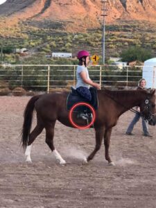 Rider on horse with circle around foot